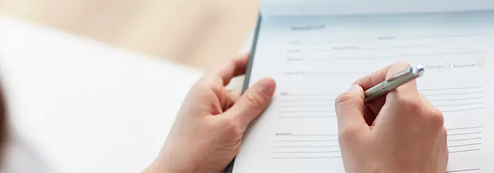 Person filling out paperwork.